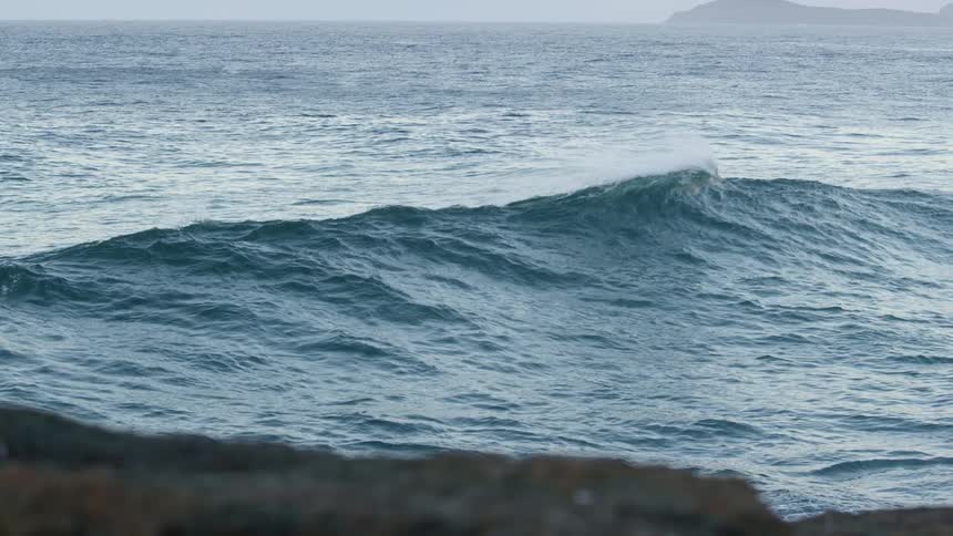Small wave breaking next to the coast