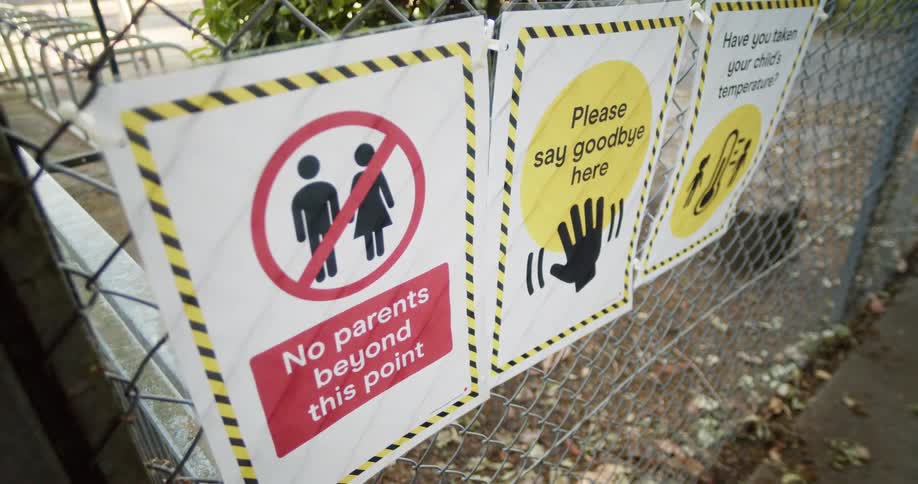 Signage posted on a metal fence at an elementary school