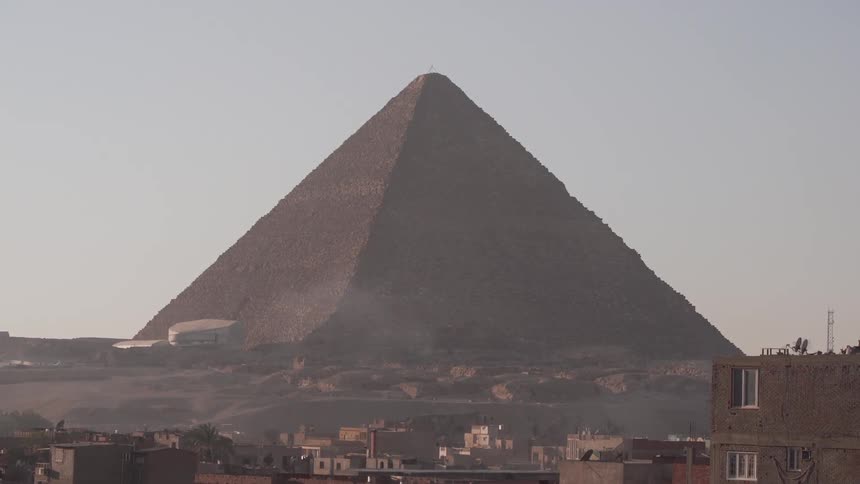 Ancient pyramid among buildings on a clear day