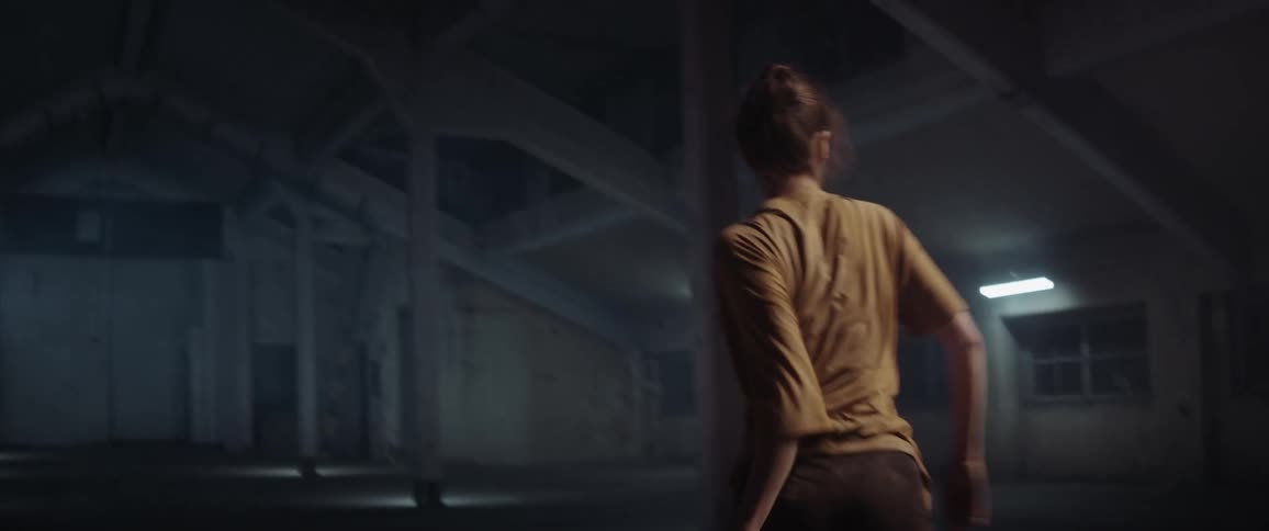 White woman dancing alone in an attic in the middle of the night