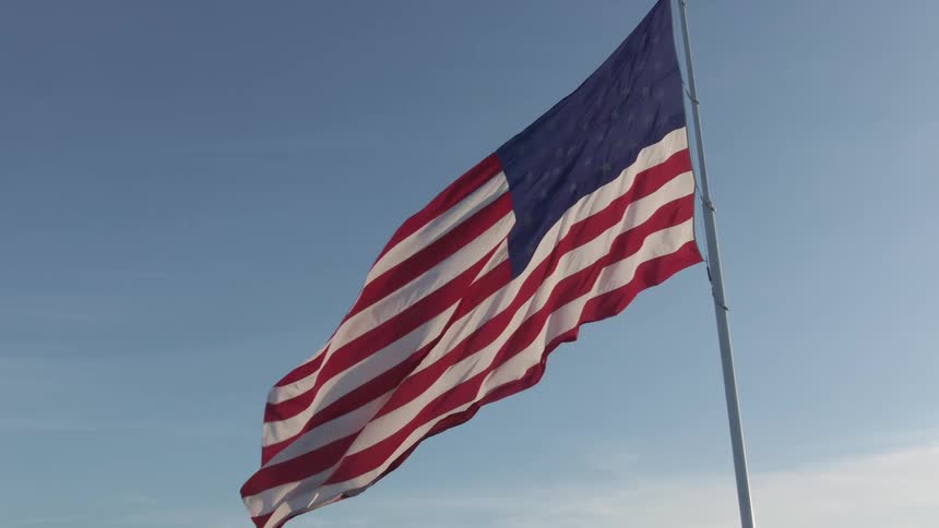 A large american flag blows in the wind