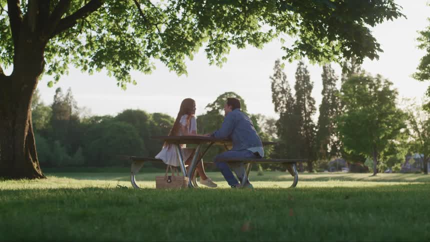 Two people sitting at a park table