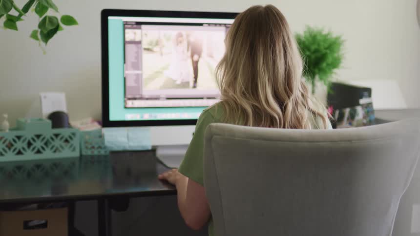 A woman is sitting in front of a computer with a photo on the screen