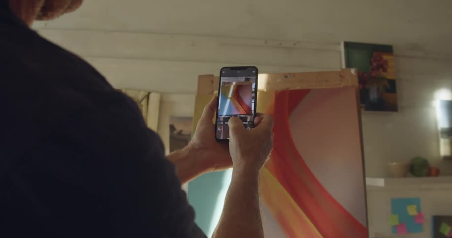 A person taking a photo of a painting