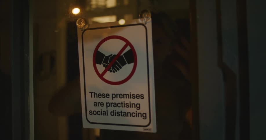 A man hangs a sign in a store window