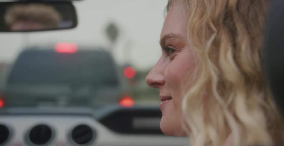 White woman sitting at the car and laughing with a man