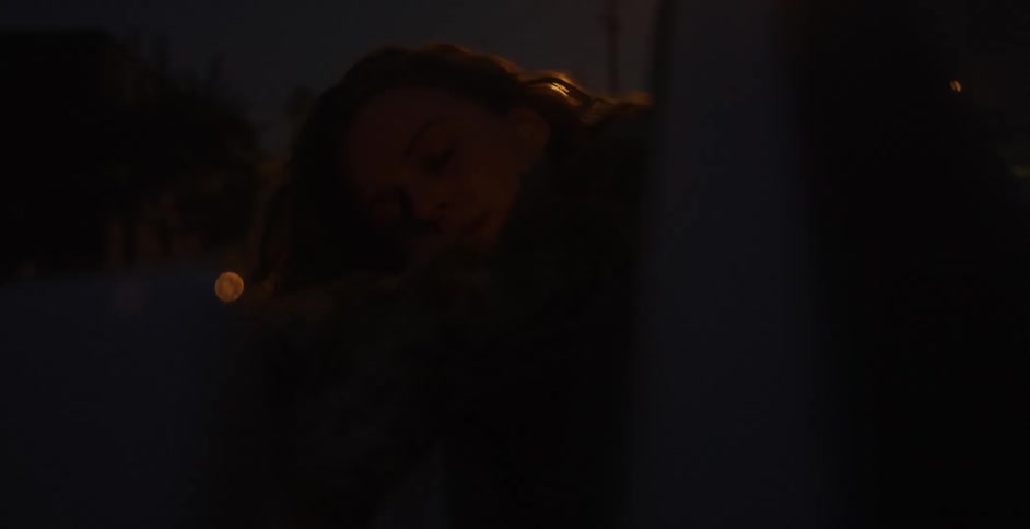 Woman sticking her head off the car window driving at night