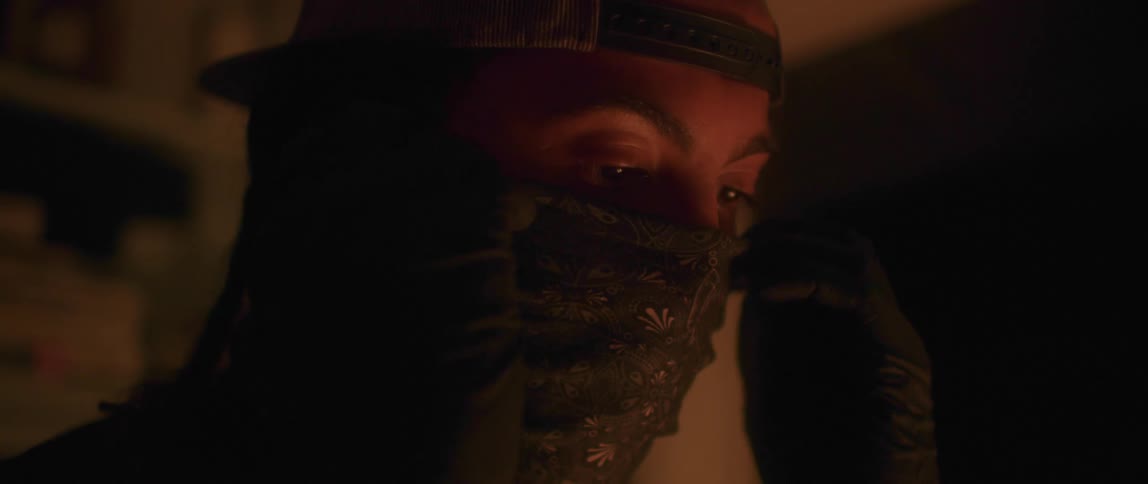 A man puts a bandana over his face