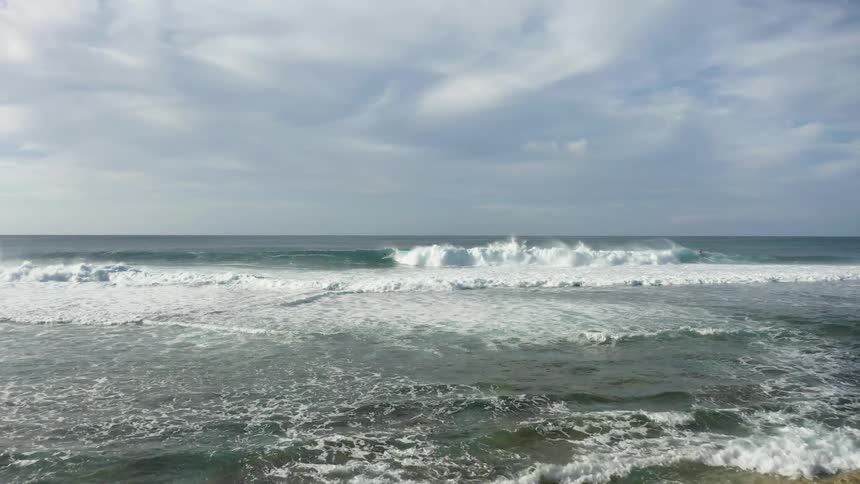 A view of ocean water moving towards the coast is displayed