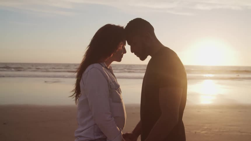 Husband and wife are standing together at the beach