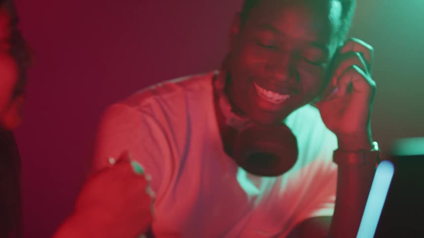 Young man wearing headphones talking with a girl on a night club