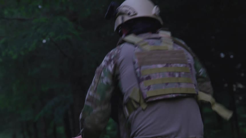 Three soldiers holding guns running through a forest at daytime