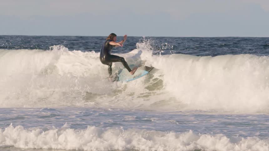 Man surfing rides a big wave as water splashes