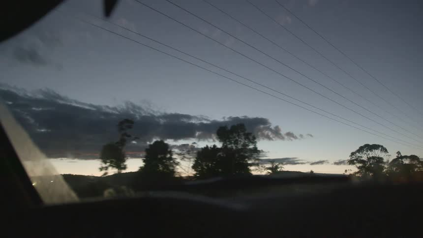 Vehicle driving on a road through a rural area at evening