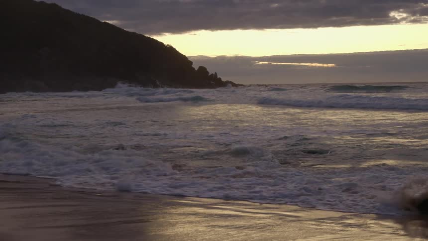 Waves rolling in to the shore as the sun sets