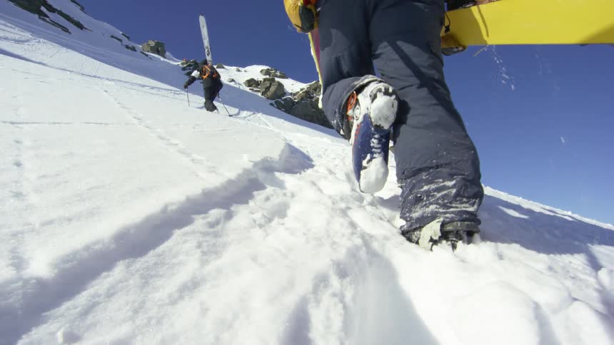 Skiers climbing the snow covered slopes of a mountain range
