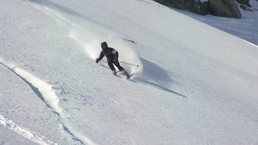 Skier sliding down the snow covered slopes of a mountain range
