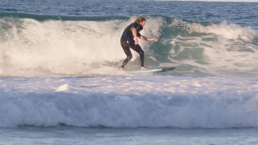 Man surfing riding big wave in splashing water on a cloudy day