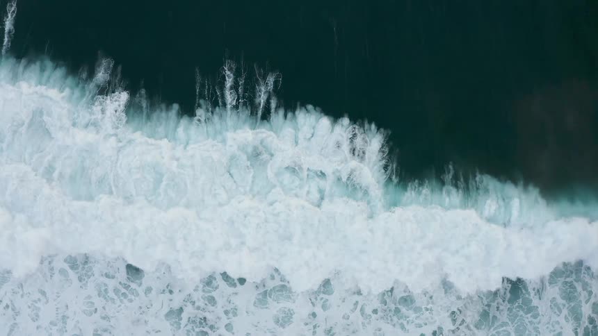 Birds eye view of waves crashing in the ocean