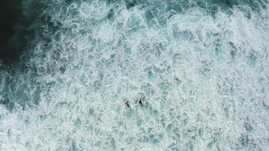 People are surfing in the ocean water