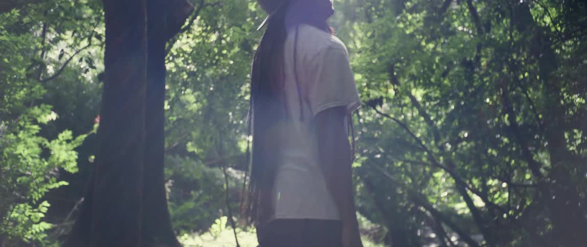 Black man walking alone contemplating the nature in the middle of the forest