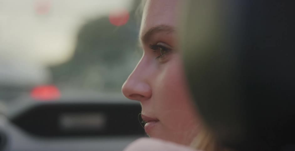 A woman is a passenger in a car during spring