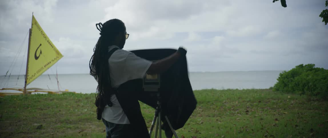 A man sets up his photography equipment on the shore