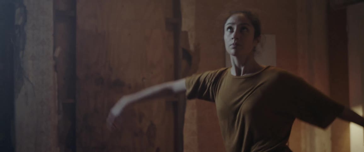 A woman is dancing in a room indoors