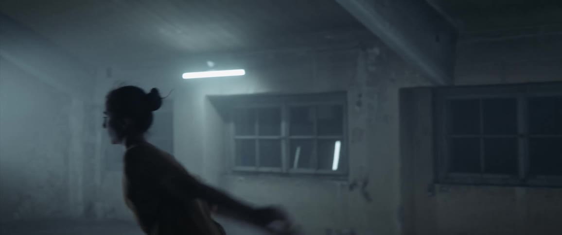 White woman dancing alone in an empty room at night