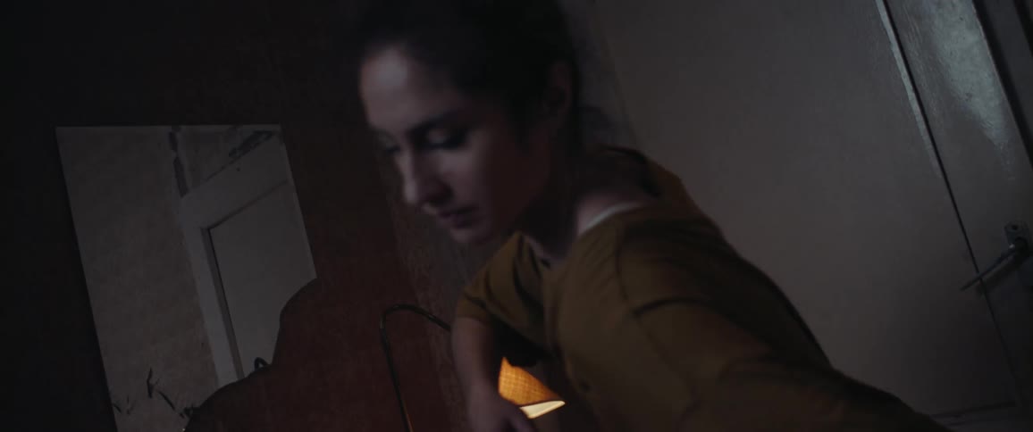 Woman dancing alone inside her room next to the door