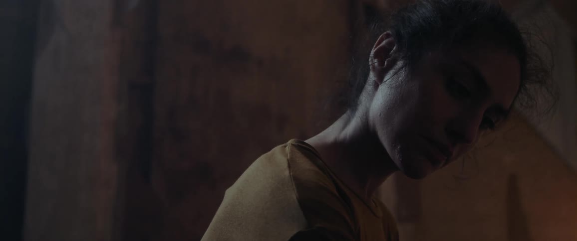 A young woman indoors looks around as a light flickers