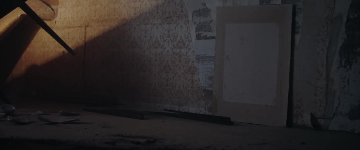 Lights flashing in a room that is destroyed as a picture frame falls off a wall and breaks