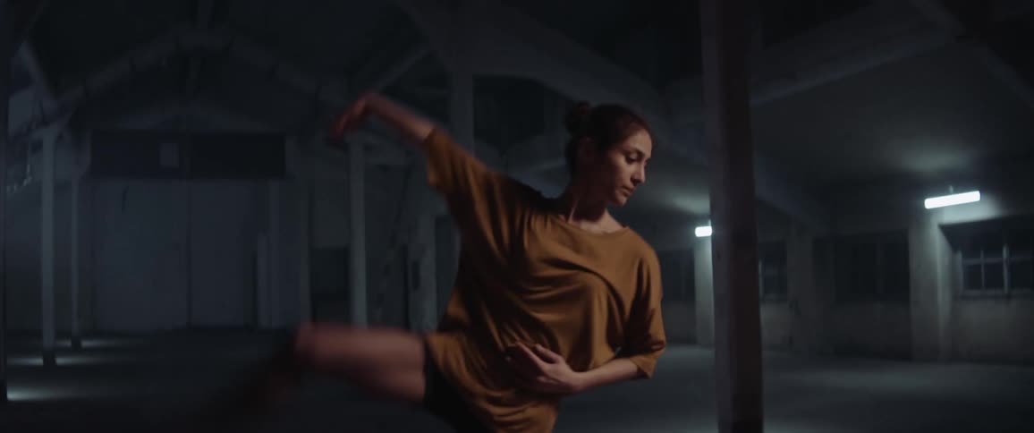 White woman dancing alone inside an attic
