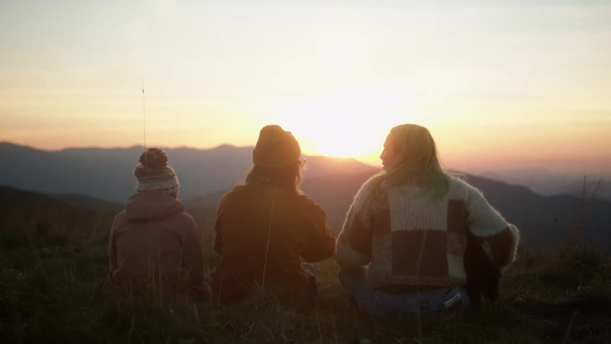 Group of girls sitting together contemplating the landscape and the mountains ahead