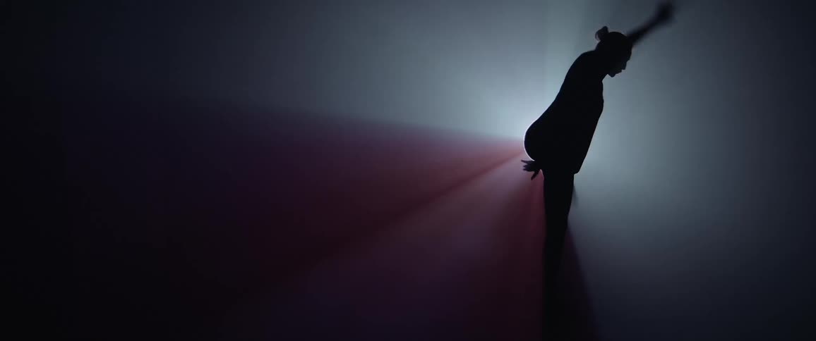 A woman is dancing by the spotlight