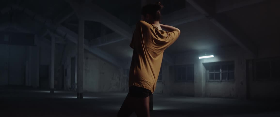A woman is dancing in a room at night