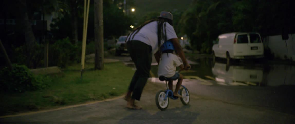 A father and son trying to ride a bike