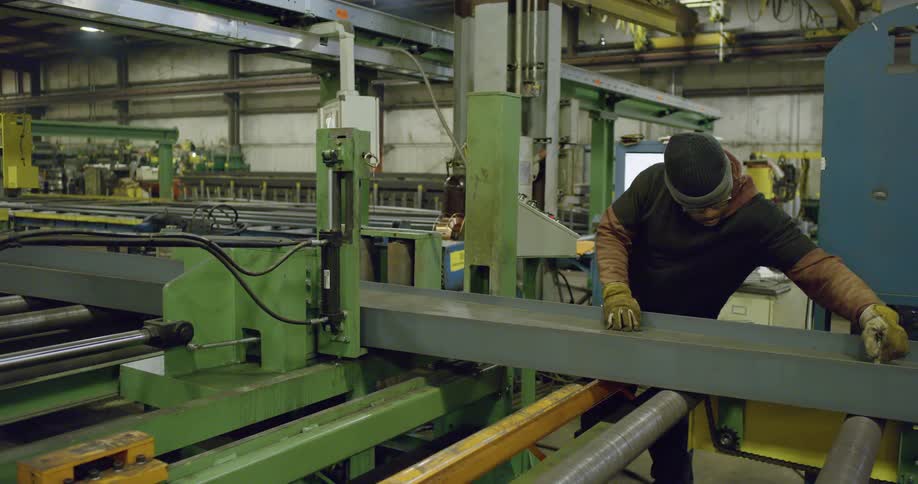 An employee cleans an assembly line in a manufacturing plant
