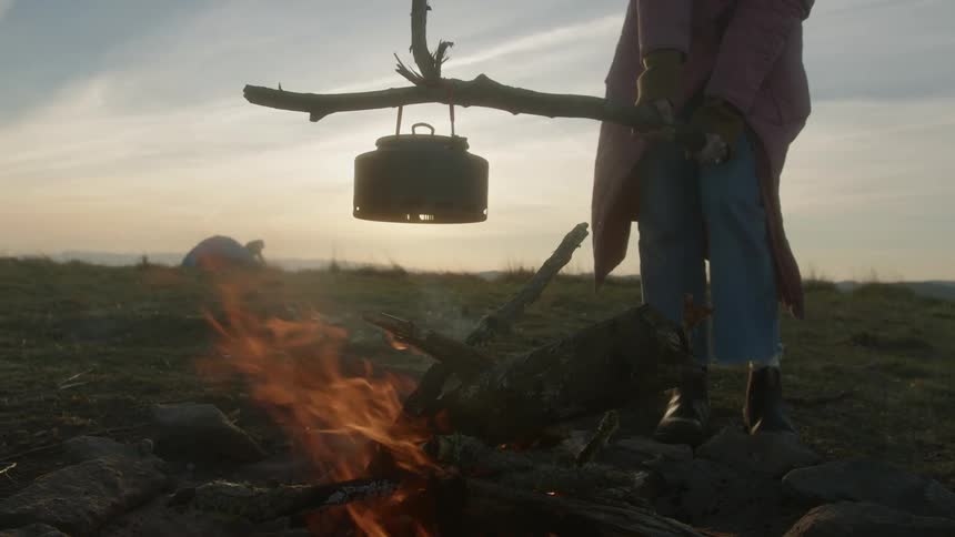 A person cooking food in a campfire