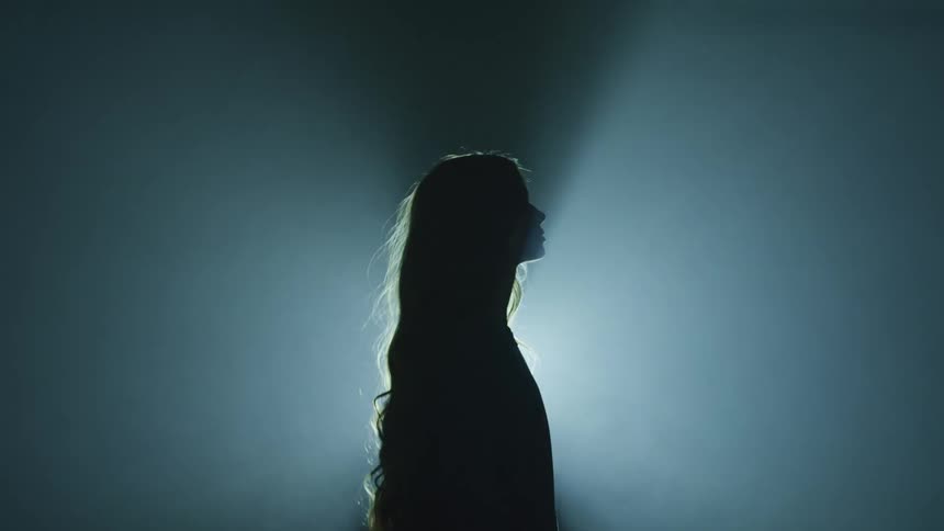 A young woman standing in front of a flashing spotlight