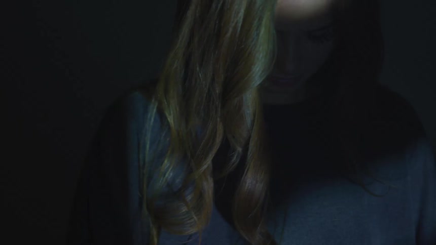 A woman is standing in a room alone