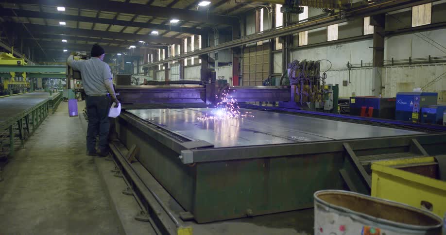 Sparks fly as a man in a factory turns on a machine