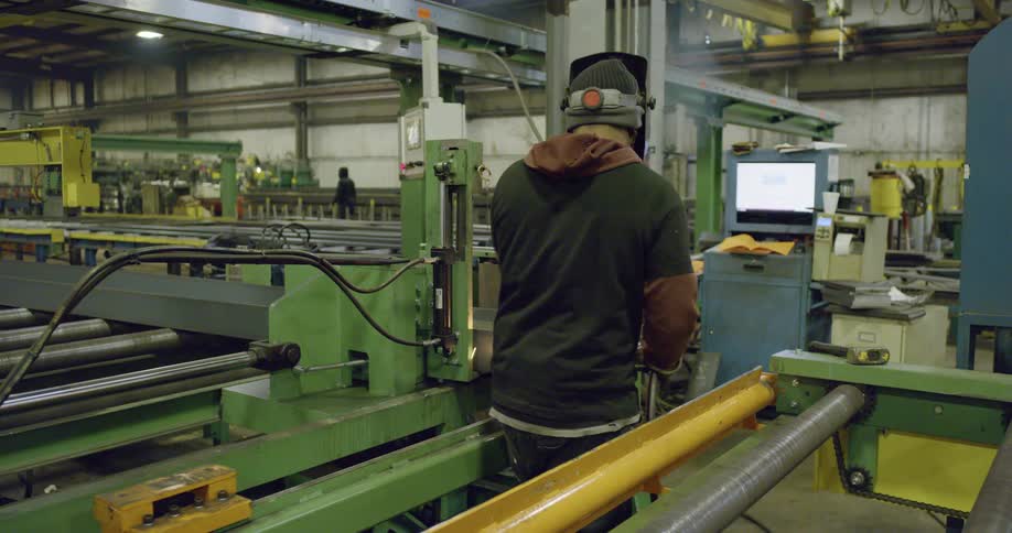 A man is welding something and then puts his torch away