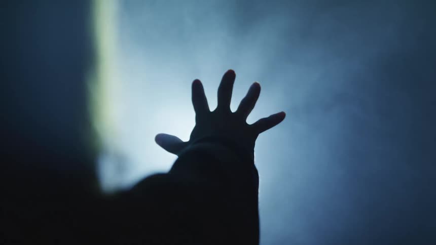 Person reaching hand towards a screen with strobing light
