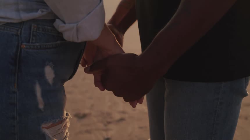 A couple hold hands outdoor
