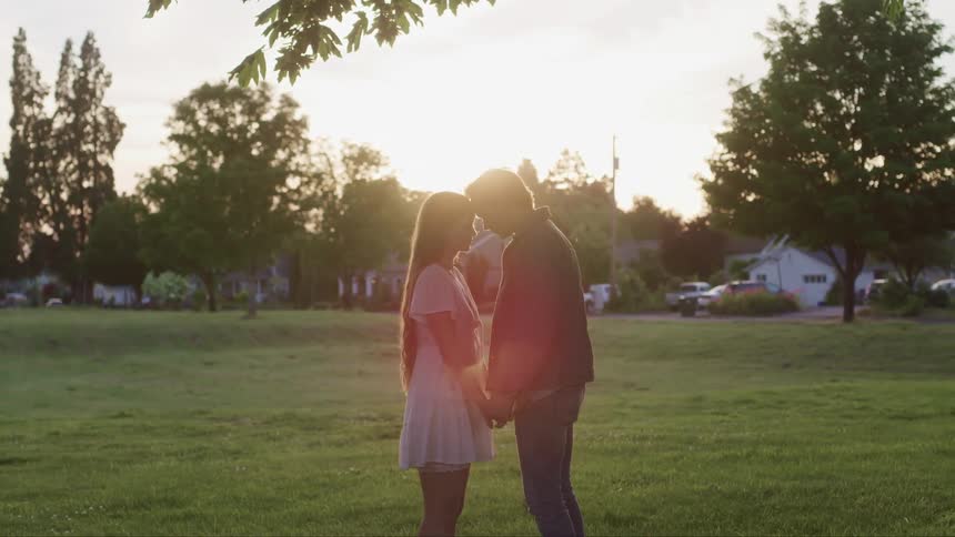 A man and a woman are holding hands and facing on another