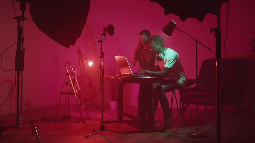 Man and woman working on a computer at the recording studio