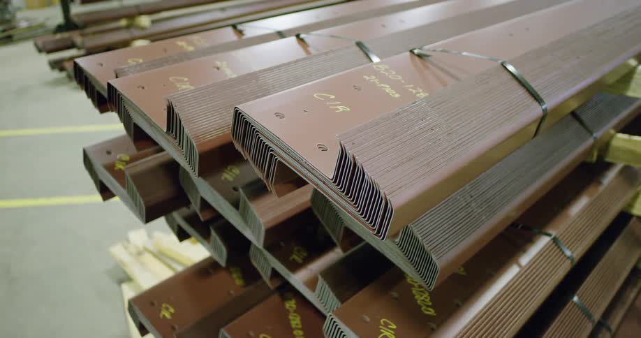 A stack of metal profiles piled up inside a warehouse