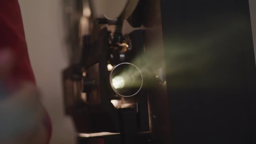 Person hovers near playing film projector