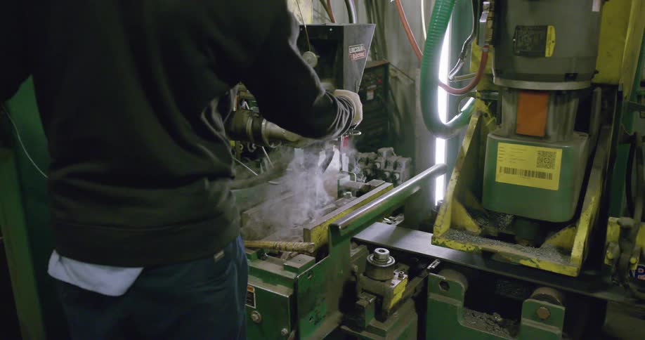 Worker machining metal on a workshop in a factory